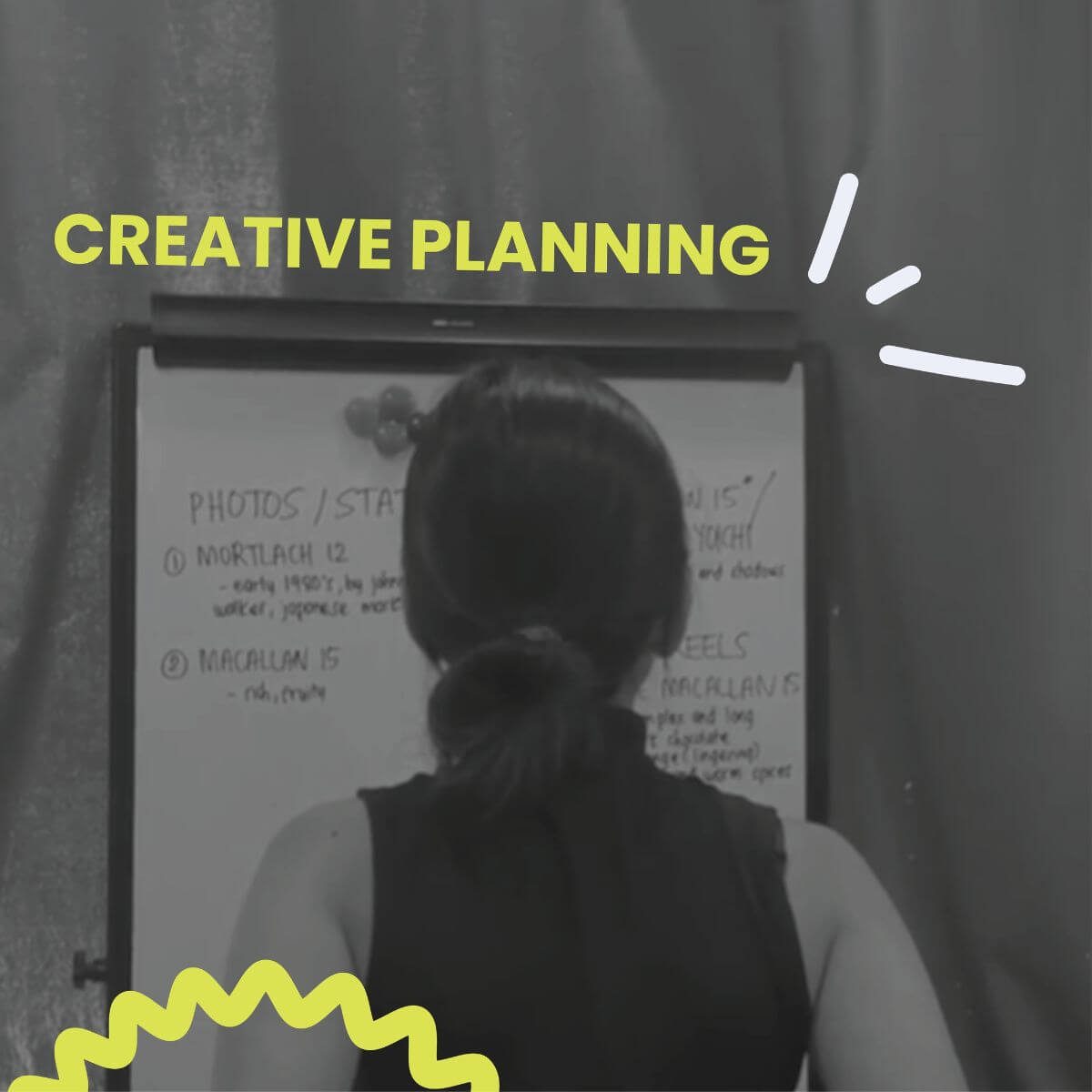 Person standing in front of a whiteboard during a creative planning session, discussing social media content ideas and campaign strategy.
